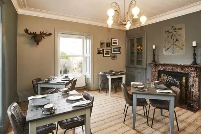 The dining room with bespoke tables and a Yorkshire montage picture above the fireplace made by Tim