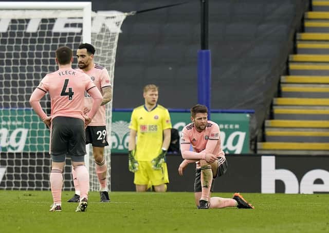 On their knees: Oliver Norwood and his Blades team-mates  look dejected after going 4-0 down against Leicester City. Picture: Andrew Yates/Sportimage