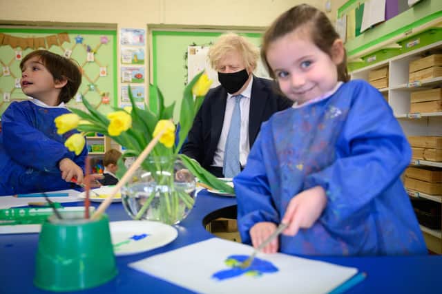 Prime Minister Boris Johnson sits and paints Tulips with children from Colham Manor primary school during a constituency visit.