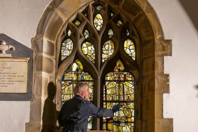 Master glazier Jonathan Cooke looks at the original 15th century medieval stained glass in Thornhill Parish church near Dewsbury which he is restoring. Picture Tony Johnson