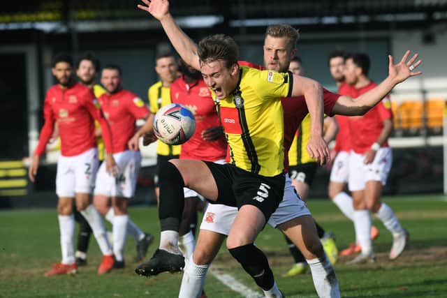 Harrogate's Will Smith is challenged by Morecambe's Harry Davis. Picture: Jonathan Gawthorpe