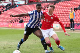 Sheffield Wednesday defender Osaze Urhoghide shields the ball ahead of Barnsley's Cauley Woodrow. Picture: PA.