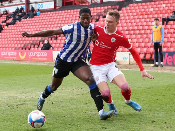 Sheffield Wednesday defender Osaze Urhoghide shields the ball ahead of Barnsley's Cauley Woodrow. Picture: PA.