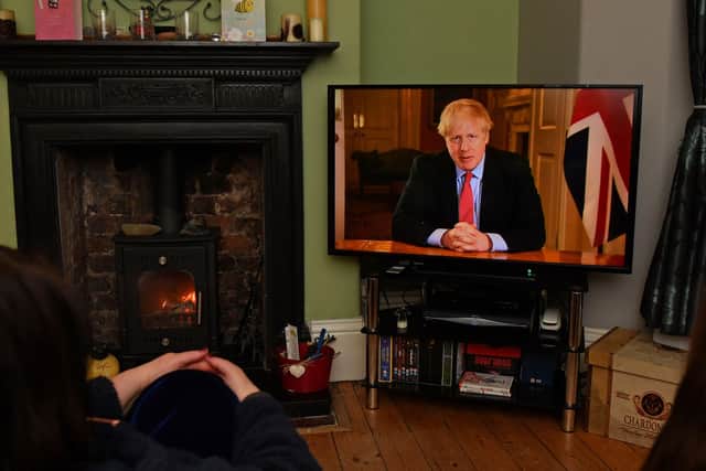 Members of a family listen as Britain's Prime Minister Boris Johnson makes a televised address to the nation from inside 10 Downing Street in London, with the latest instructions to stay at home to help contain the Covid-19 pandemic, from a house in Liverpool on March 23, 2020.(Photo by PAUL ELLIS/AFP via Getty Images)