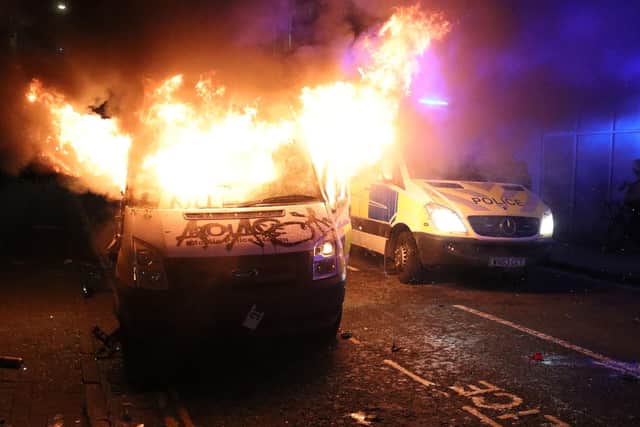 A vandalised police van on fire outside Bridewell Police Station, as other police vehicles arrive after protesters demonstrated against the Government's controversial Police and Crime Bill.