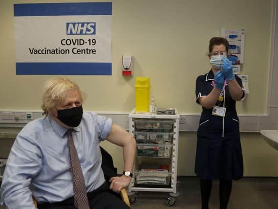 Prime Minister Boris Johnson prepares to receive the first dose of AstraZeneca vaccine administered by nurse and Clinical Pod Lead, Lily Harrington at Westminster Bridge Vaccination Centre at St Thomas' Hospital in London. Picture: Aaron Chown/PA.