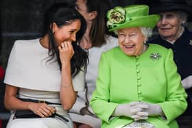 Queen Elizabeth II sitts and laughs with Meghan, Duchess of Sussex during a ceremony to open the new Mersey Gateway Bridge on June 14, 2018 in the town of Widnes in Halton, Cheshire, England. (Photo by Jeff J Mitchell/Getty Images)