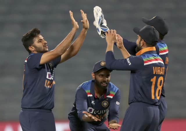 India's Shardul Thakur, left, celebrates with teammates the dismissal of England's Jos Buttler during the first One Day International. (AP Photo/Rafiq Maqbool)