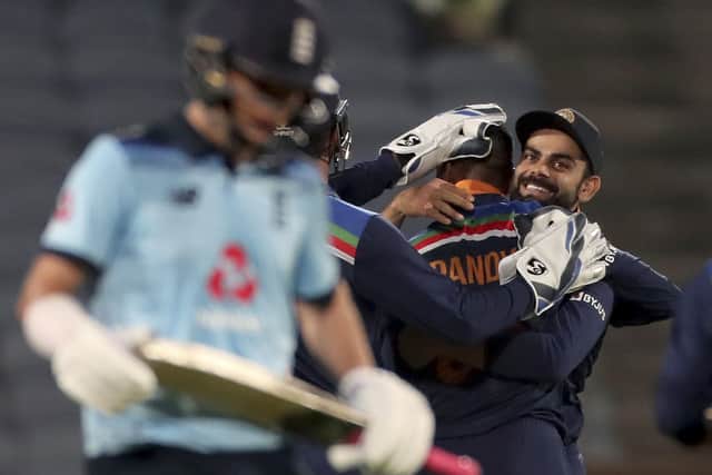 India's captain Virat Kohli, right, hugs team-mate Krunal Pandya to celebrate the dismissal of England's Sam Curran. (AP Photo/Rafiq Maqbool)