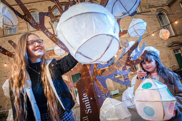 Pictured, Frances Short (left) and Annabel Fox interacting with the new special metal tree, designed by Matt Kitchen-Dunn has been installed in front of the Lawrence Batley Theatre, in Huddersfield. Photo credit: Huddersfield Literature Festival