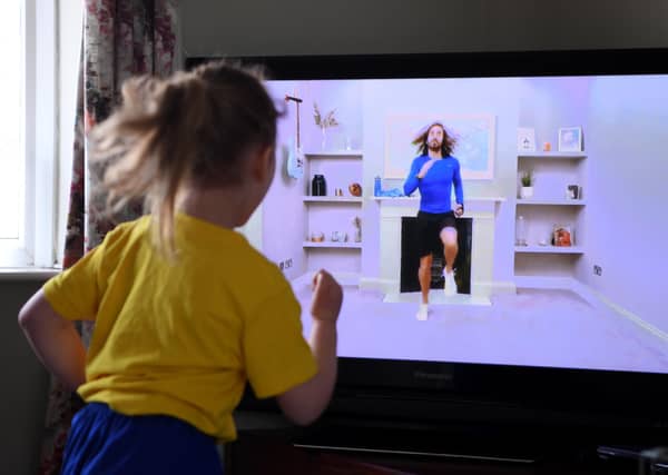 A young girl follows a Joe Wicks workout during the first lockdown.