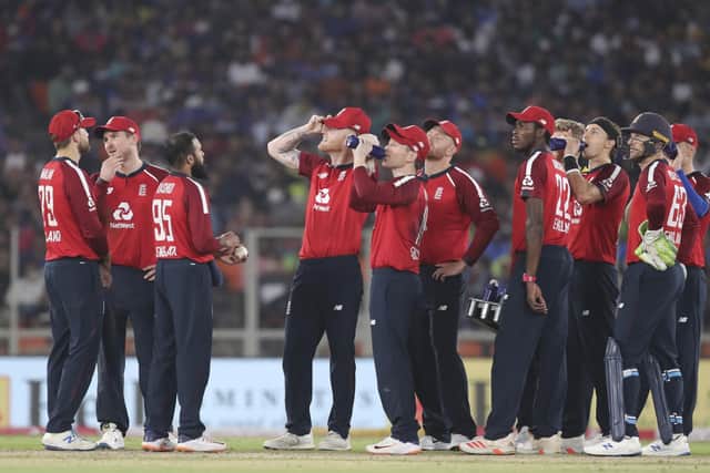 England's players take a break as they await the third umpire decision for the wicket of India captain Virat Kohli during the second Twenty20 clash in Ahmedabad. Picture: Photo/Aijaz Rahi
