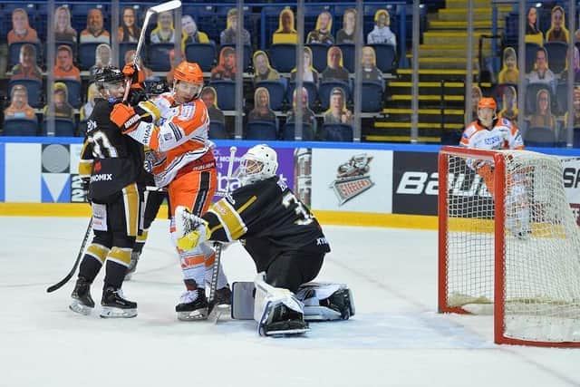 Jonathan Phillips (hidden) tips in Kevin Schulze's blast past an unsighted Ben Bowns to open the scoring for Sheffield Steelers at the National Ice Centre. Picture courtesy of Dean Woolley.