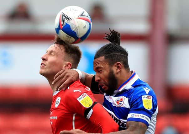 Barnsley's Cauley Woodrow (left) and Reading's Liam Moore battle for the ball. Pictures: PA