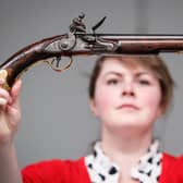Alice Fitton holds a flintlock pistol once owned by William Rivers
