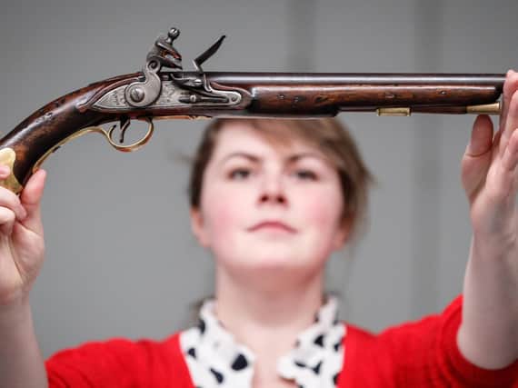 Alice Fitton holds a flintlock pistol once owned by William Rivers
