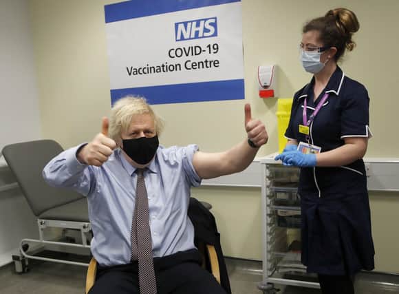 Prime Minister Boris Johnson gives thumbs up after receiving the first dose of AstraZeneca vaccine administered by nurse and Clinical Pod Lead, Lily Harrington at Westminster Bridge Vaccination Centre at St Thomas' Hospital in London where he was treated for Covid.
