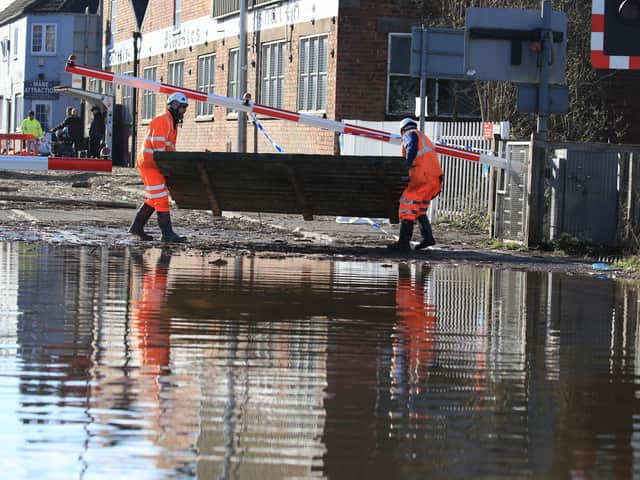Workmen clear debris from the road as floodwater began to recede in Snaith, Yorkshire. Photo: Danny Lawson/PA Wire