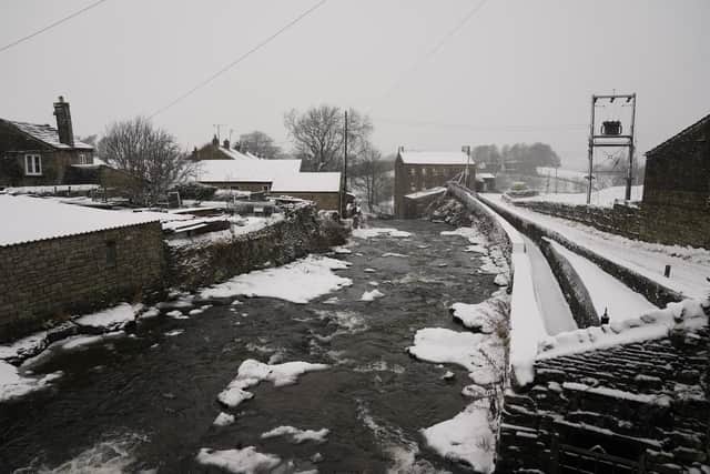 Gayle Mill, (rear right) dating from about 1784, thought to be the oldest structurally unaltered cotton mill in existence covered in a light dusting of snow in Hawes, North Yorkshire.