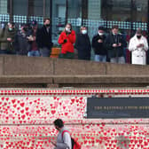 Members of the public queue for Covid-19 vaccinations and booster jabs at St Thomas' Hospital beside the The National Covid Memorial Wall, a focal point for the country's grief.