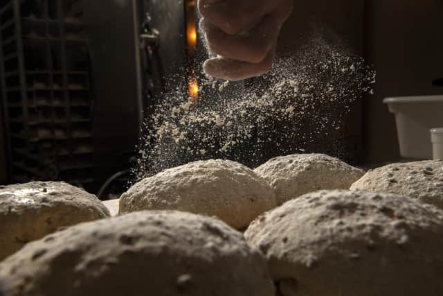 Paul dusting his sourdough loaves. (Bruce Rollinson).