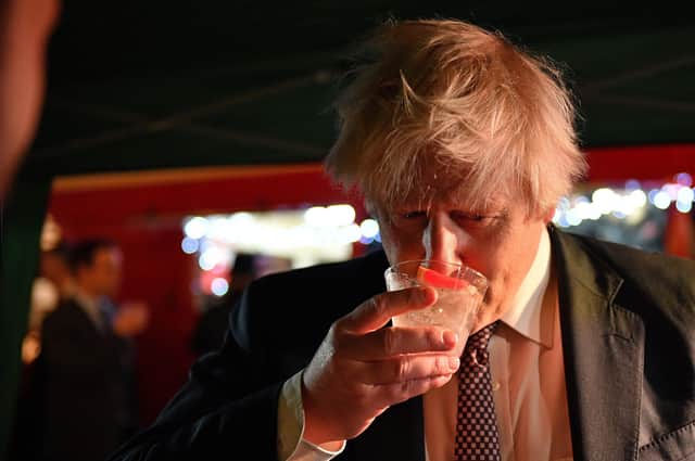 .File photo dated 30/11/21 of Prime Minister Boris Johnson samples an Isle of Harris Gin as he visits a UK Food and Drinks market. However it is questions about his presence at Downing Street parties that is the latest crisis to afflict his government,