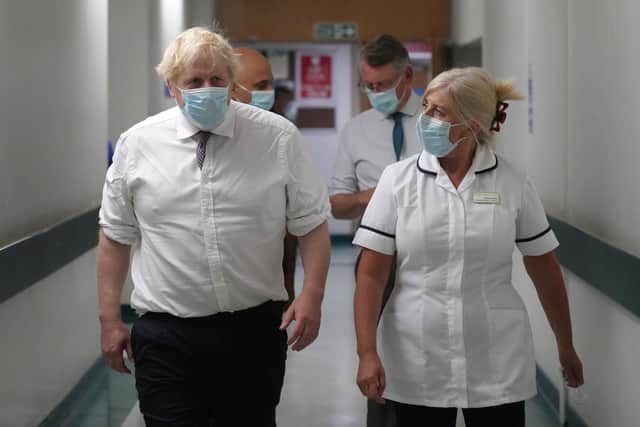 Prime Minister Boris Johnson and Health Secretary Sajid Javid (left rear hidden) speak with staff as they view an MRI scanner during a visit to Leeds General Infirmary in West Yorkshire.