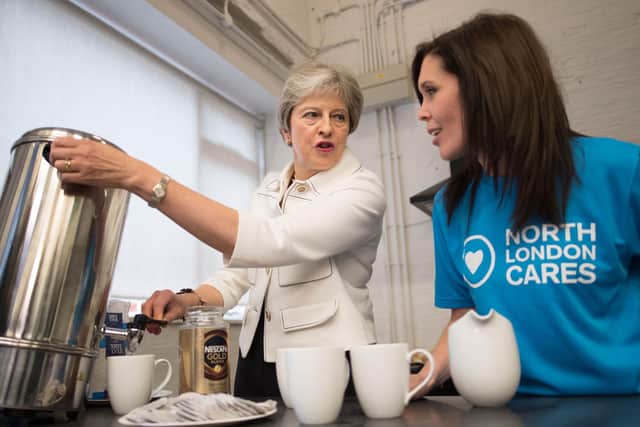 Prime Minister Theresa May pours hot water from an urn in to a mug during a meeting at a social group in Vauxhall Gardens Community Centre in London, run by a charity working to combat loneliness at the launch of the first loneliness strategy in 2018.