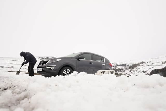 A man digs out a car from snow in High Green in the Yorkshire Dales, amid freezing conditions in the aftermath of Storm Arwen. Image: Danny Lawson/PA Wire