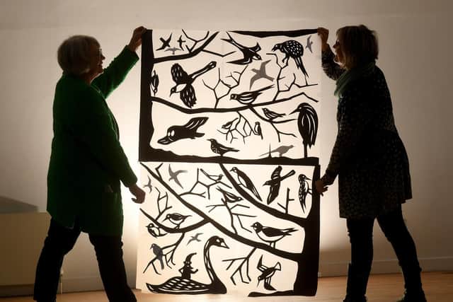 Gill Bond (right) and Frances Noon hold one of the Illuminated windows at the Watershed, Slaithwaite