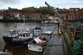 Fisherman undertake maintenance on their fishing boats whilst moored in the harbour at Whitby  Photo by Oli Scarff/AFP via Getty Images
