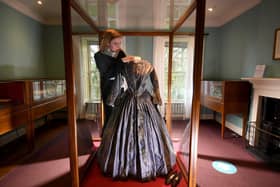 Exhibition of Charlotte Bronte clothing items at the Bronte Parsonage, Haworth. Deputy visitor experience manager Emma Littlejohns is pictured with a Striped Silk Dress worn by Charlotte Bronte. Image: Simon Hulme