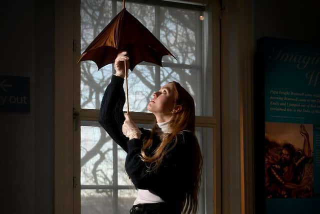 Exhibition of Charlotte Bronte clothing items at the Bronte Parsonage, Haworth. Deputy visitor experience manager Emma Littlejohns is pictured with a small brown parasol. Image: Simon Hulme