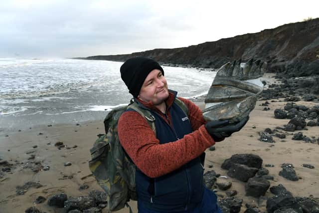 Hull fossil hunter Mark Kemp pictured on the beach at Mappleton, with the Temnodontosaurus jaw section he found there. Picture : Jonathan Gawthorpe