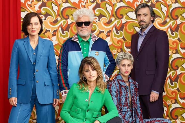 The cast of Parallel Mothers including the film's director Pedro Almodovar and actress Penelope Cruz, pictured in a green jacket and sitting in this photograph on a red chair.