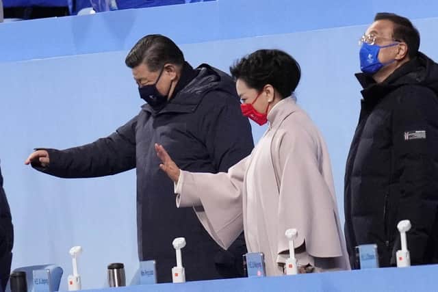 Chinese President Xi Jinping waves with his wife Peng Liyuan during the opening ceremony of the 2022 Winter Olympics, Friday, Feb. 4, 2022, in Beijing. (AP Photo/Bernat Armangue)