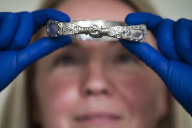 Jenny Truran, conservator at Lancashire County Museums Service, holds a Viking silver arm ring that would have acted as portable currency Picture: Danny Lawson/PA Wire