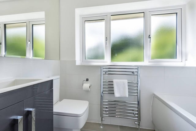 The  luxury house bathroom comprises of a three-piece white suite with shower unit over the bath.