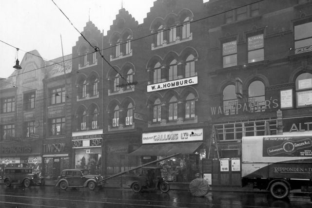 Shops on New Market Street in January 1938. From the left is Hepworth's, Timpson's, Weaver To Wearer Ltd, R.S. Boulton Ltd tobacconist, W.A. Homburg theatrical outfitter (upper floor), Gallons Limited grocers, All British Wallpaper Store, Abraham Altham tea merchants. Also Althams Tourist Office and railway and steamship company on the upper floor.