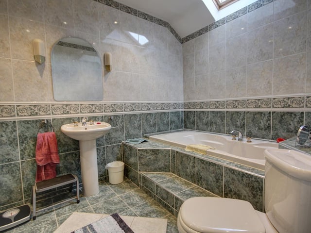 A jacuzzi spa bath is a luxury feature of the family bathroom, that also has a step-in shower.