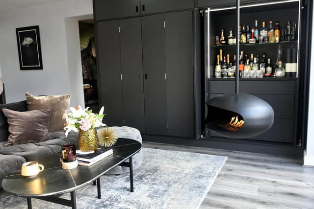 The open plan living space with a bioethanol fire and drinks cabinet