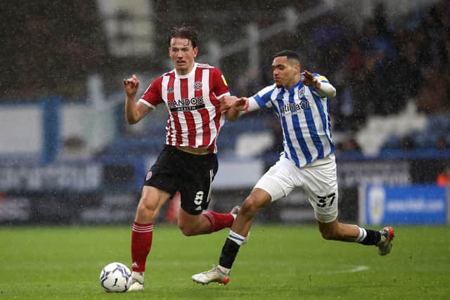 Contrasting value: Sheffield United's Sander Berge (left) and Huddersfield Town's Jon Russell (Picture: Isaac Parkin/PA)
