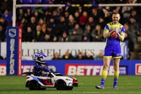 Warrington Wolves' Ben Currie is amused as Whizzy Rascal arrives with the match ball. (Alex Whitehead/SWpix.com)