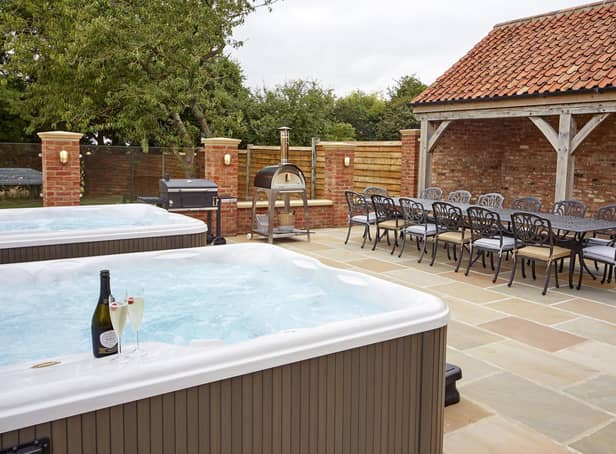 Space for all outside with two hot tubs, a dining area and barbecue