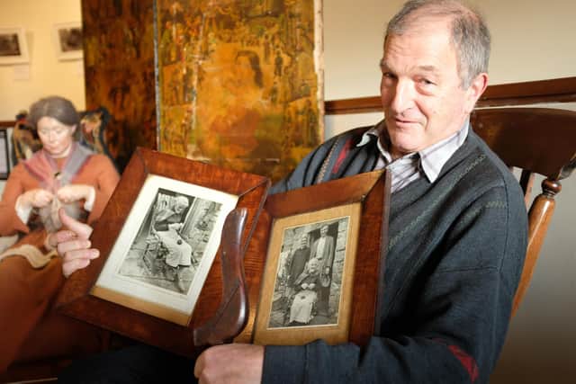 Dennis Iveson at the DCM exhibition of knitting sticks, holding Martha Dinsdale's knitting stick and photographs of her with her son Owen Tom and daughter Lizzie.