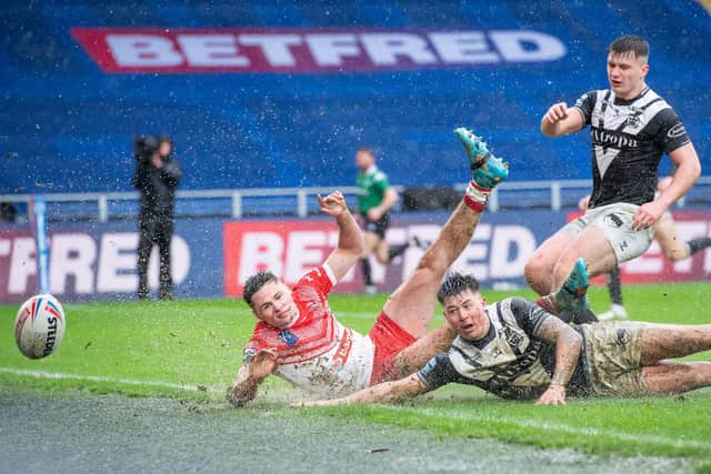 MAKING A SPLASH: St Helens's Jack Welsby scores a try against Hull FC as Jamie Shaul attempts to prevent it. Picture by Allan McKenzie/SWpix.com