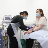 Holly Fox (right) takes part in screening before she receives a Moderna Omicron COVID-19 booster vaccine in a clinical study at St George's, University of London, in Tooting, south west London