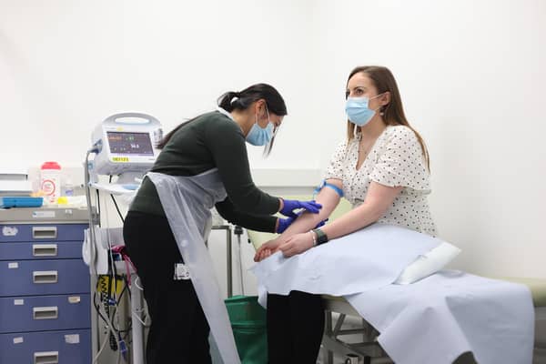 Holly Fox (right) takes part in screening before she receives a Moderna Omicron COVID-19 booster vaccine in a clinical study at St George's, University of London, in Tooting, south west London