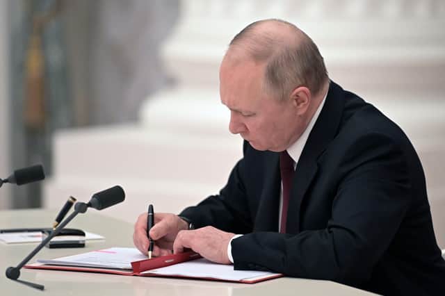 Russian President Vladimir Putin signs a document recognizing the independence of separatist regions in eastern Ukraine, escalating the possibility of a geo-political conflict in the region.