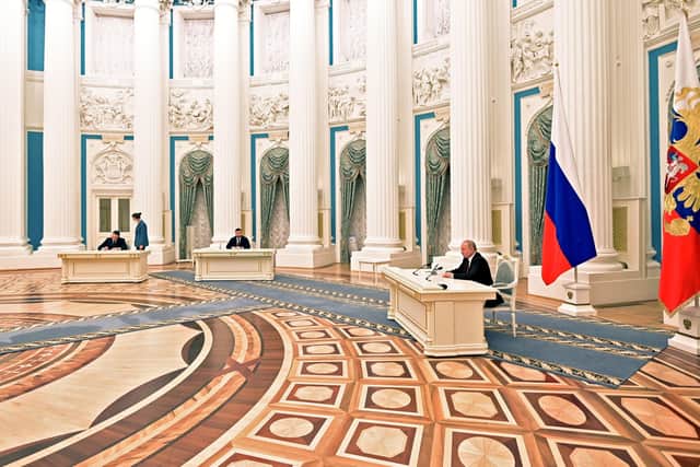 Russian President Vladimir Putin signs a document in the Kremlin on Monday night recognising the independence of separatist regions in eastern Ukraine, escalating the possibility of a geo-political conflict in the region.